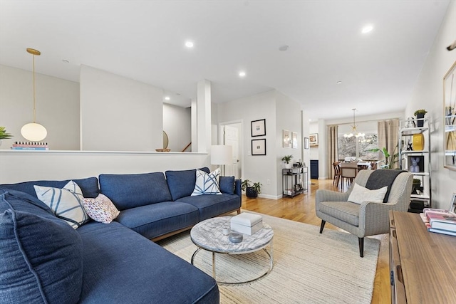 living room featuring a chandelier and light wood-type flooring