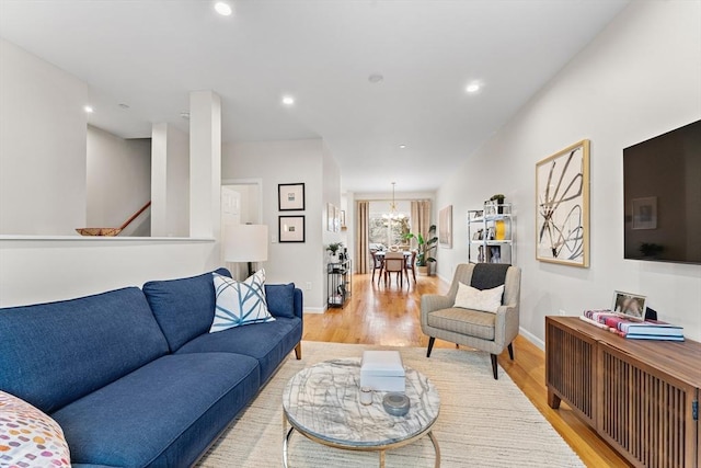 living room featuring a chandelier and light wood-type flooring