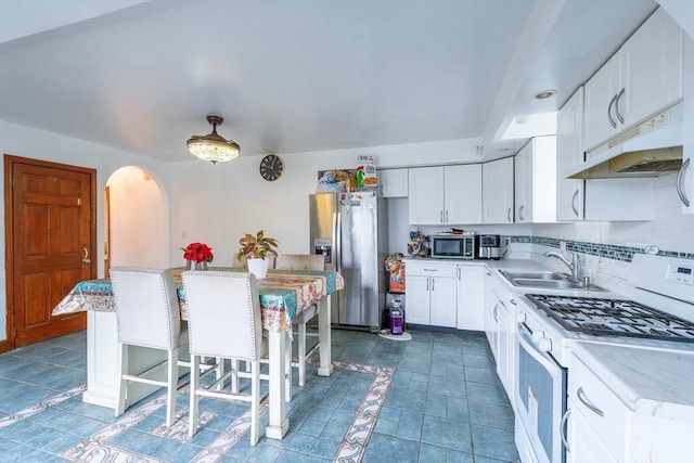 12 Charles St, Brockton, MA 02301 - kitchen featuring stainless steel appliances, under cabinet range hood, arched walkways, white cabinets, and tasteful backsplash