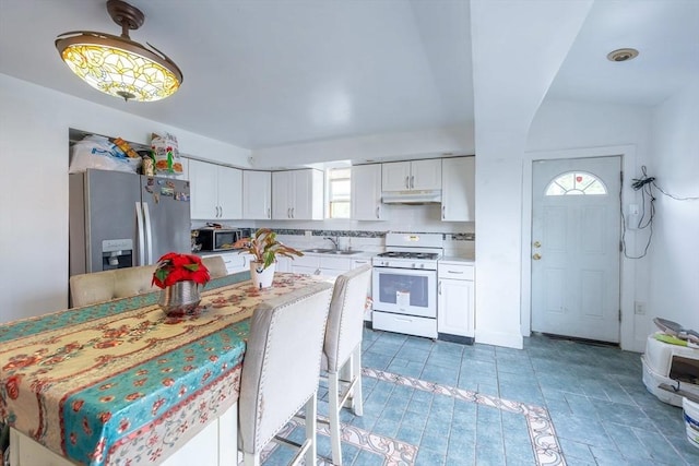 12 Charles St, Brockton, MA 02301 - kitchen featuring stainless steel appliances, under cabinet range hood, white cabinets, and plenty of natural light