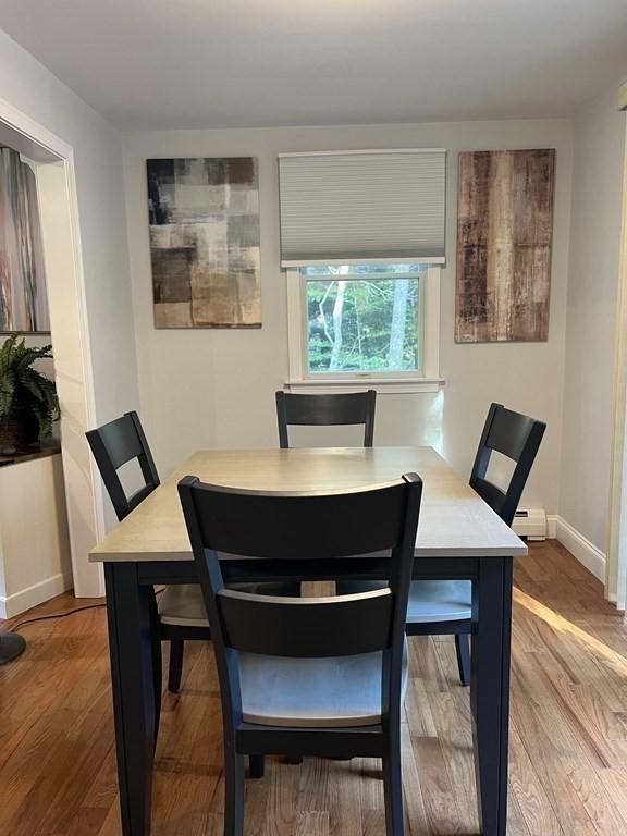dining room featuring baseboards, wood finished floors, and baseboard heating