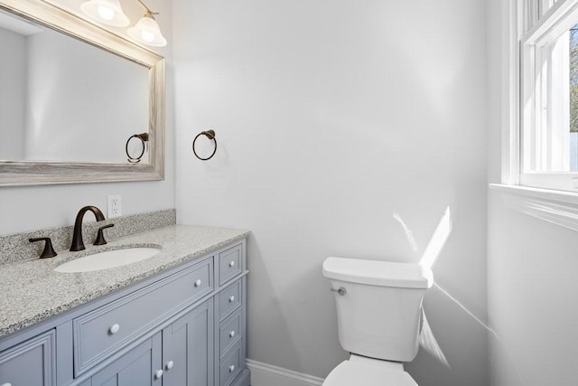 bathroom with vanity, baseboards, and toilet