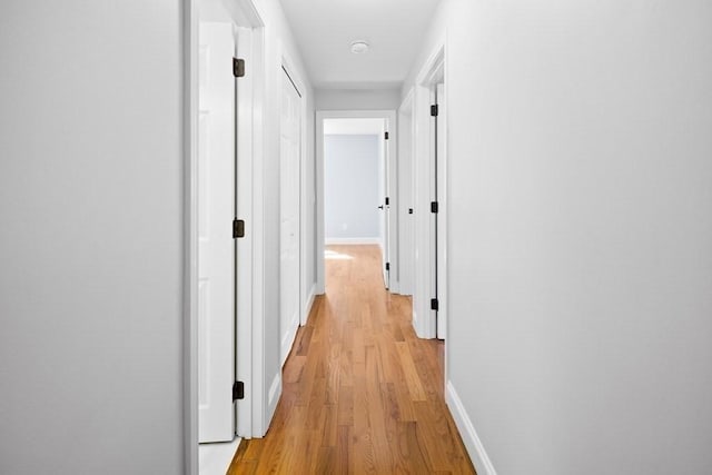 hallway with baseboards and light wood-style floors