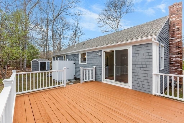 wooden terrace featuring an outdoor structure and a shed