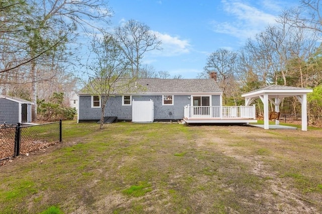rear view of property with a yard, a gazebo, and a wooden deck