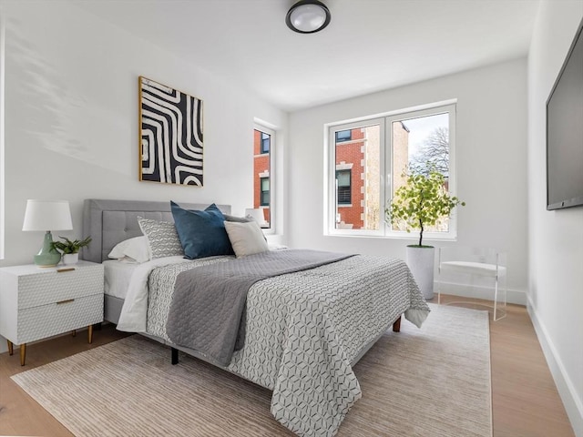 bedroom featuring baseboards and light wood-style flooring