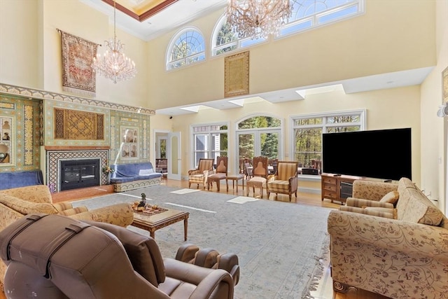 30 Bridle Path, Shrewsbury, MA 01545 - living area with crown molding, wood finished floors, a fireplace, a high ceiling, and a notable chandelier