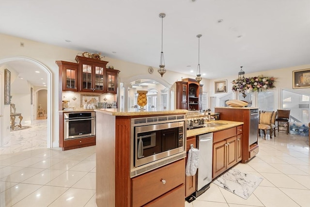 30 Bridle Path, Shrewsbury, MA 01545 - kitchen featuring a center island, arched walkways, light countertops, and stainless steel appliances
