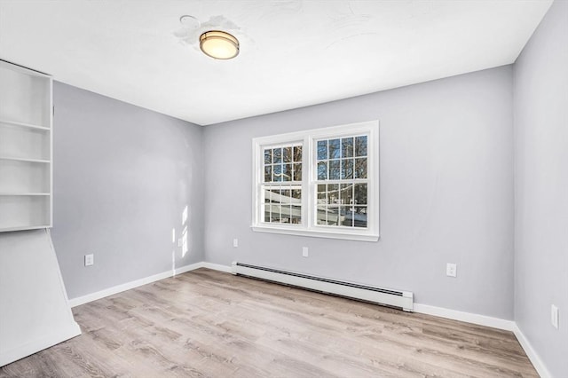 unfurnished room with light wood-type flooring and a baseboard heating unit