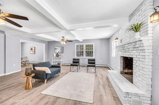 living room with beamed ceiling, ceiling fan, light hardwood / wood-style floors, and a fireplace