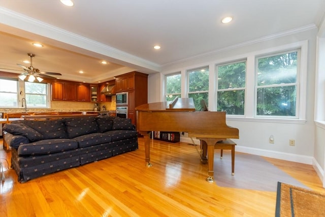 living room with light wood-style floors, ornamental molding, baseboards, recessed lighting, and ceiling fan