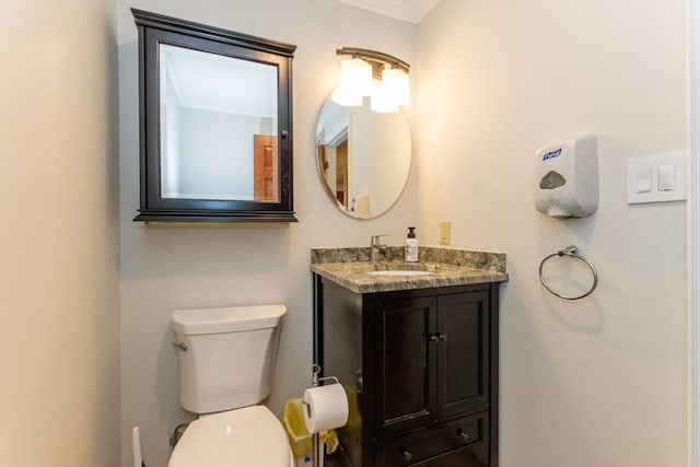 bathroom featuring vanity, toilet, and crown molding