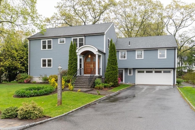 view of front of home with a garage, driveway, and a front lawn