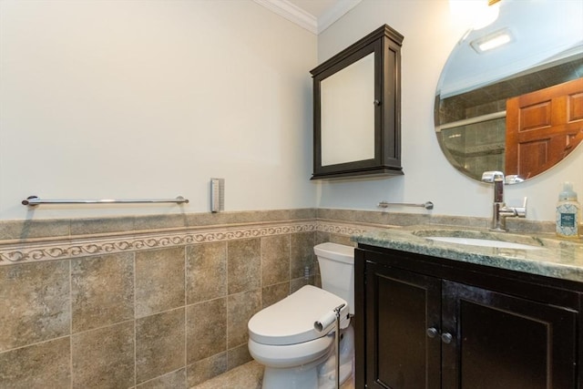 bathroom featuring ornamental molding, tile walls, tiled shower, vanity, and toilet