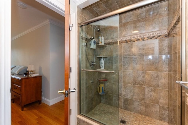 full bath featuring ornamental molding, a stall shower, wood finished floors, and baseboards