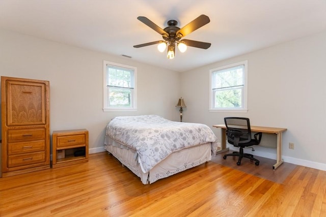 bedroom with light wood-type flooring, baseboards, and a ceiling fan