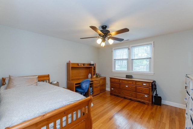 bedroom with light wood-style flooring, baseboards, and a ceiling fan