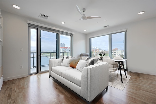 living room featuring a healthy amount of sunlight, ceiling fan, and hardwood / wood-style flooring