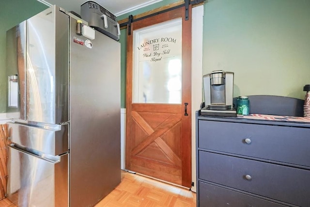 interior space with freestanding refrigerator and a barn door