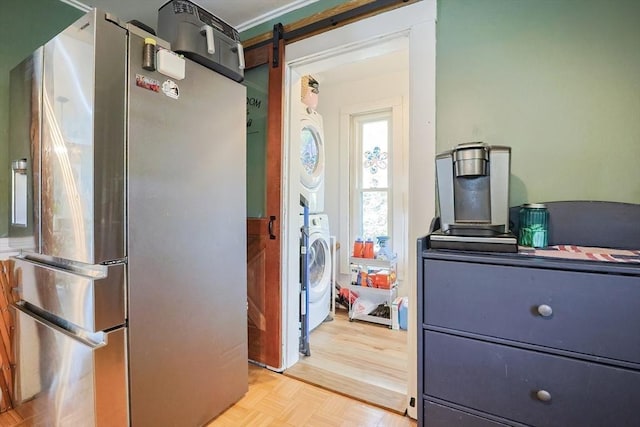 kitchen featuring freestanding refrigerator and stacked washer / drying machine
