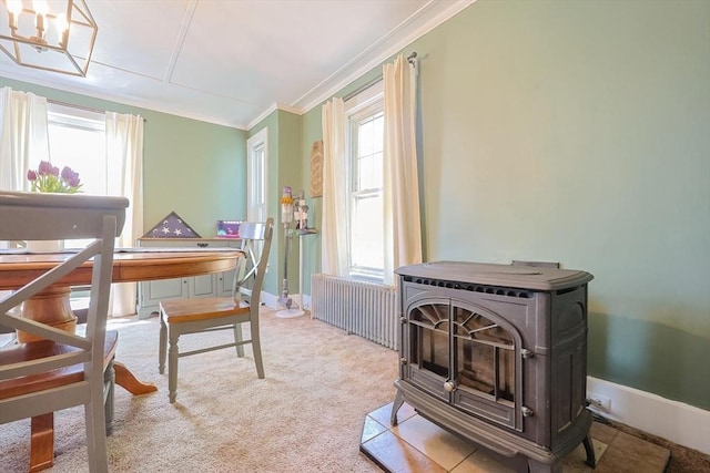 carpeted office space featuring crown molding, a wood stove, baseboards, a notable chandelier, and radiator
