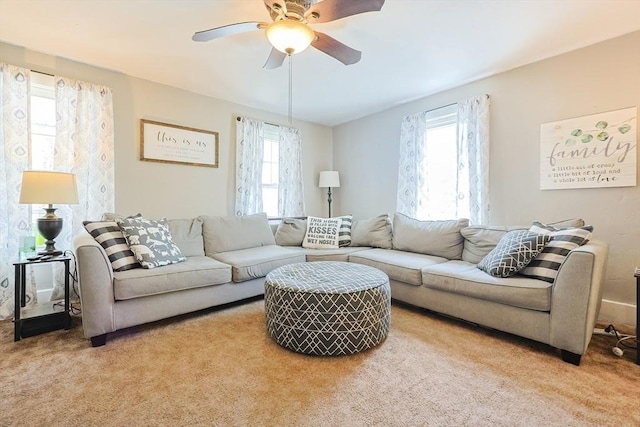 living area with carpet floors, ceiling fan, and plenty of natural light