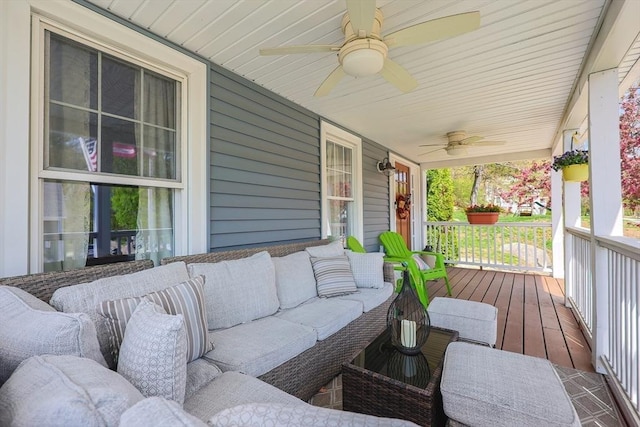 wooden terrace with a porch, ceiling fan, and an outdoor living space