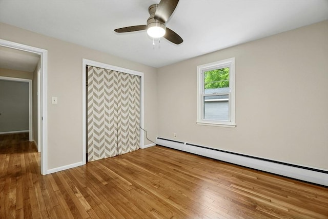 15 Dodge Hill Rd, Sutton, MA 01590 - unfurnished bedroom featuring a baseboard heating unit, light wood-style floors, a closet, baseboards, and a ceiling fan