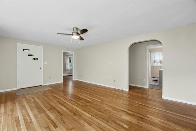 15 Dodge Hill Rd, Sutton, MA 01590 - unfurnished living room featuring arched walkways, light wood-style flooring, ceiling fan, and a baseboard radiator