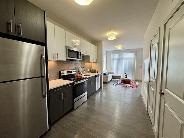 99 Tremont Unit 205, Boston, MA 02135 - kitchen with stainless steel appliances, light countertops, tasteful backsplash, dark wood-style flooring, and white cabinetry
