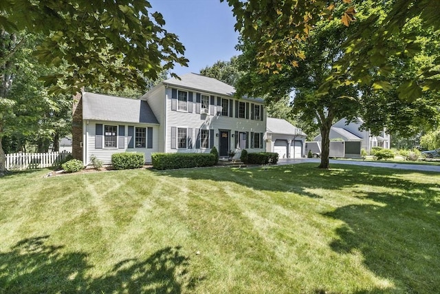 colonial inspired home with a garage and a front lawn