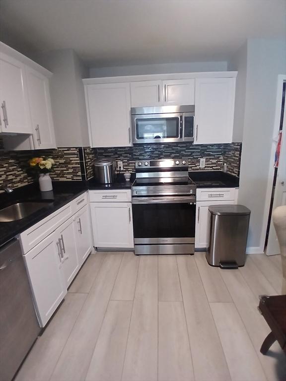 474 Revere Beach Blvd Unit 205, Revere, MA 02151 - kitchen with stainless steel appliances, white cabinetry, and dark countertops