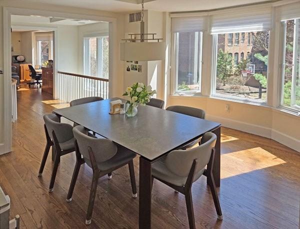 dining space with plenty of natural light, baseboards, and wood finished floors