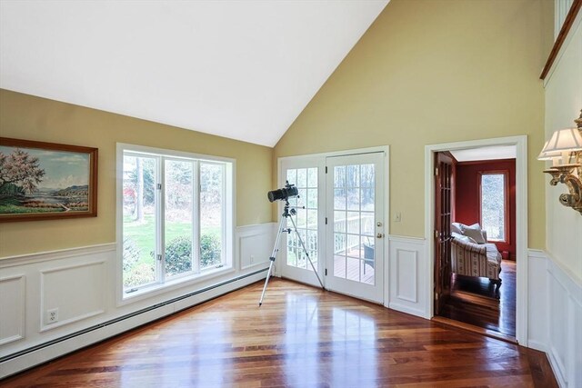 entryway with a wealth of natural light, a wainscoted wall, and baseboard heating
