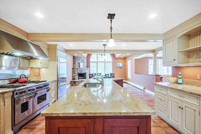 kitchen with wall chimney exhaust hood, a baseboard heating unit, a sink, premium appliances, and open shelves