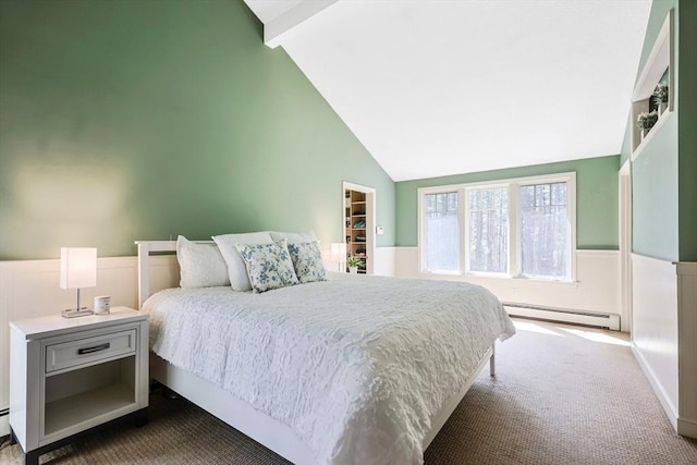bedroom featuring a baseboard heating unit, lofted ceiling with beams, dark colored carpet, and a wainscoted wall