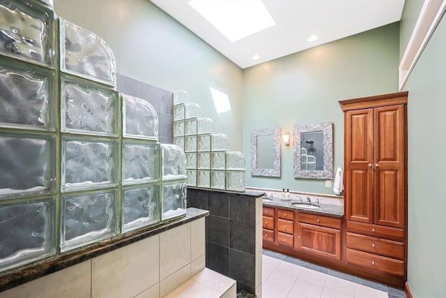 bathroom featuring a skylight, vanity, tile patterned flooring, and a walk in shower