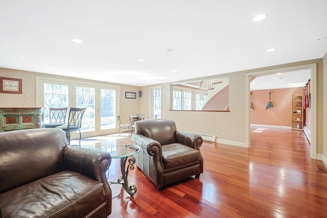living room featuring baseboards, wood finished floors, baseboard heating, and plenty of natural light