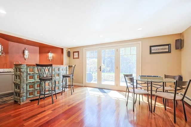 dining area featuring baseboards, french doors, wood finished floors, and recessed lighting