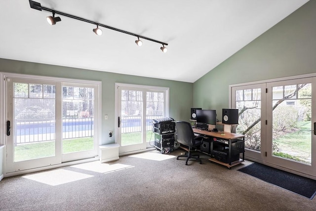 carpeted office featuring vaulted ceiling and rail lighting