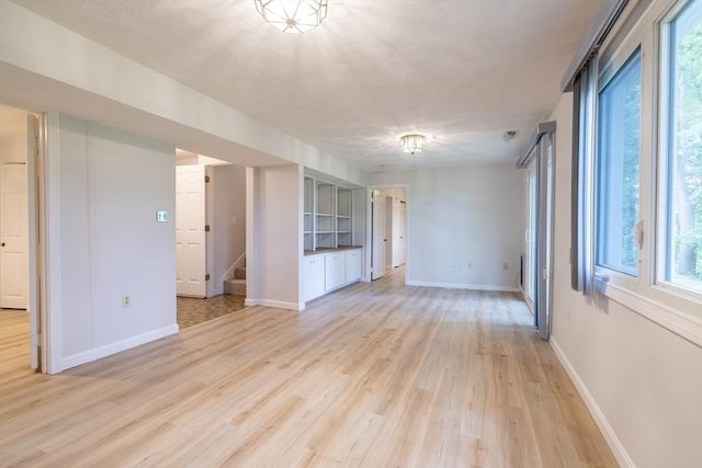 87 Fifer Ln Unit 87, Lexington, MA 02421 - unfurnished living room with light wood-style flooring and stairway
