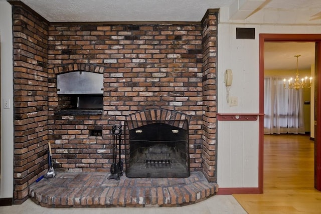 27 Chestnut Hill, South Hadley, MA 01075 - detailed view of a chandelier, a fireplace, wood finished floors, and a textured ceiling