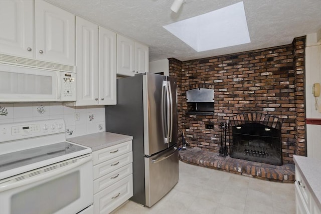 27 Chestnut Hill, South Hadley, MA 01075 - kitchen featuring white appliances, a skylight, a textured ceiling, white cabinets, and light countertops