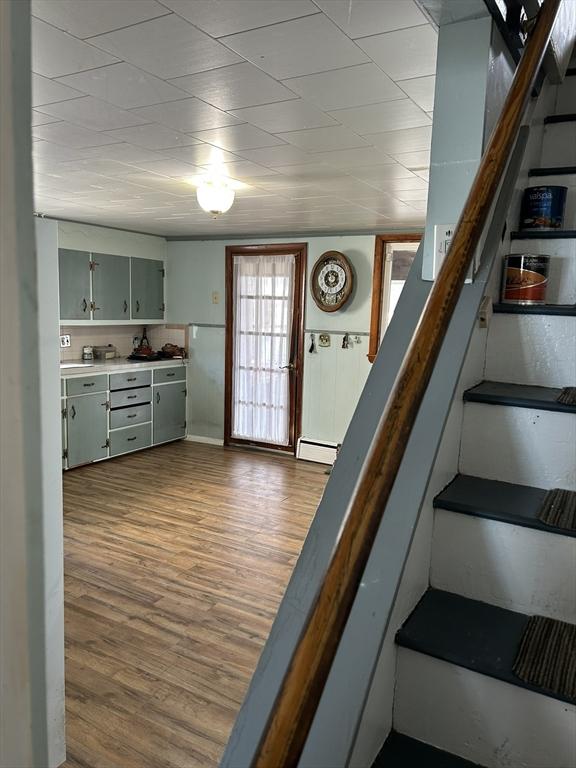 interior space featuring a baseboard heating unit and wood finished floors