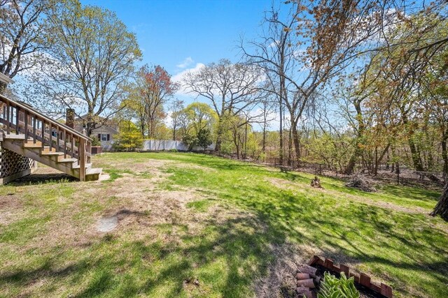 view of yard with a fenced backyard and stairway