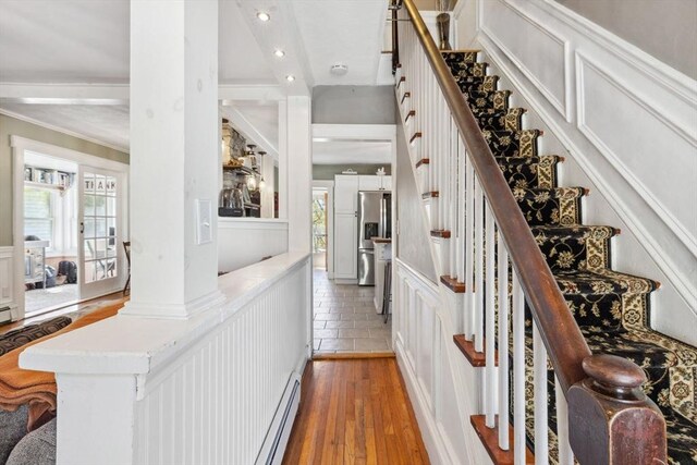 interior space featuring light wood-style floors, stairs, a decorative wall, and a healthy amount of sunlight