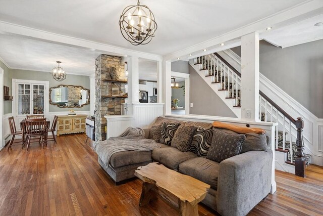 living area featuring crown molding, a chandelier, stairway, and hardwood / wood-style flooring