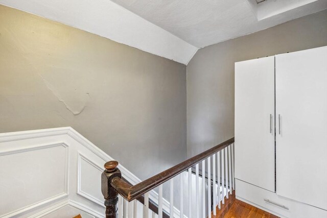 stairs with lofted ceiling and wood finished floors