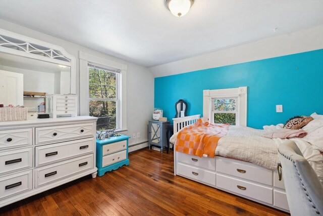 bedroom with a baseboard radiator, dark wood finished floors, and lofted ceiling
