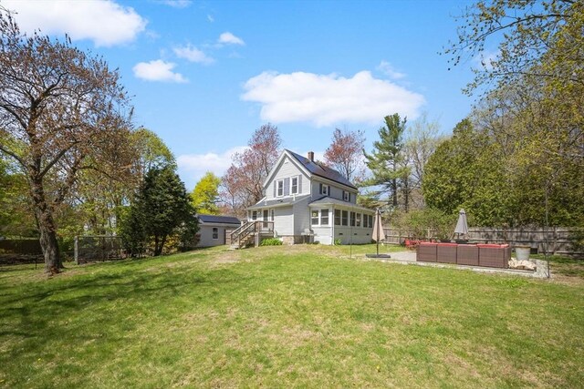 back of house featuring outdoor lounge area, a fenced backyard, a chimney, a lawn, and a patio